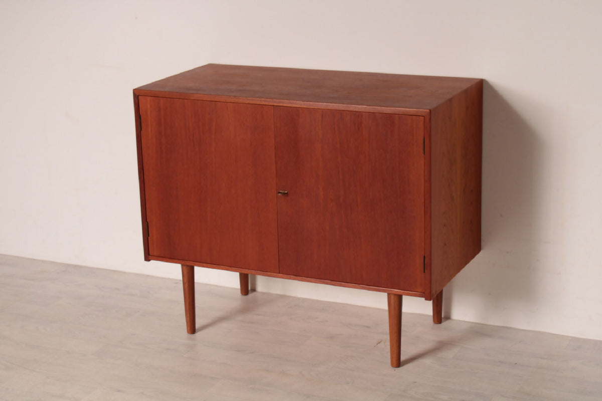 Elegant skænk i teak af Hans J. Wegner, set fra en vinkel. Det smukke træ og de rene linjer gør den velegnet til enhver indretning.