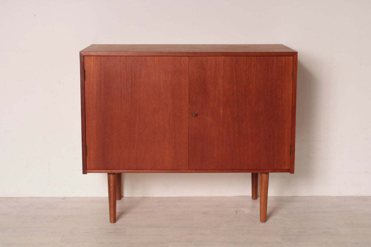 Tidløs Hans J. Wegner skænk i teak med lukkede låger. Eksklusivt håndværk fra Ry Møbelfabrik, ideel til stilfuld opbevaring i hjemmet.