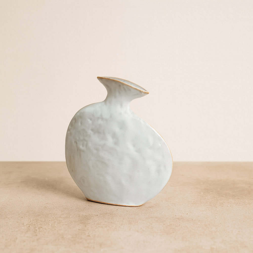 Model vase designet af Project 213A i 2021. Et unikt håndlavet stykke i stentøj, der opstod ud fra en lykkelig hændelse i værkstedet, hvor en ellers rund vase faldt ned fra bordet og blev flad. Resultatet er en legende og skulpturel form, som adskiller sig fra klassiske vaser.