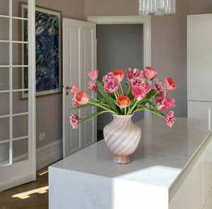 Lyserød vintage Murano vase med tulipaner på sofabord. Klassisk italiensk design, ideel til stilfuld boligindretning.