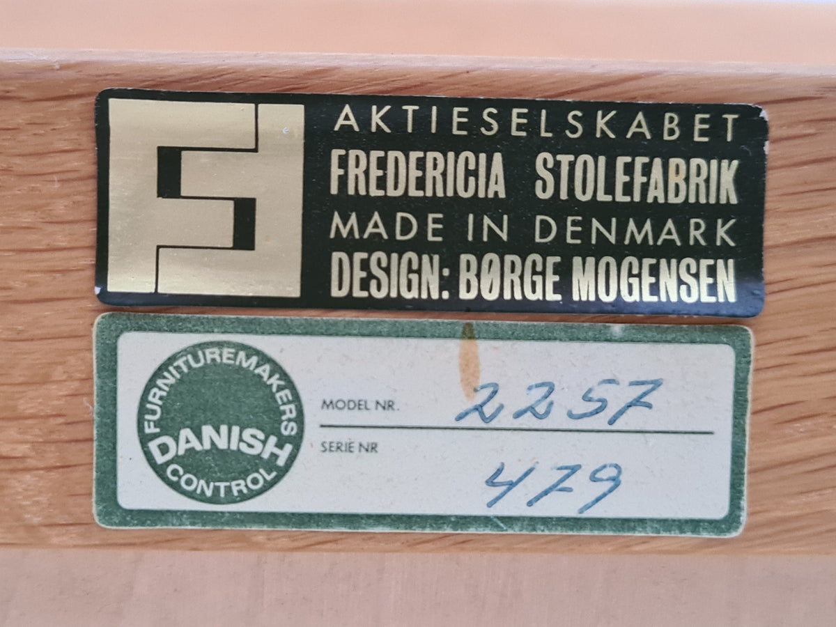 Fredericia Stolefabrik mærkat og modelnummer 2257 på Børge Mogensen lænestol, fremhæver dansk design og autenticitet.