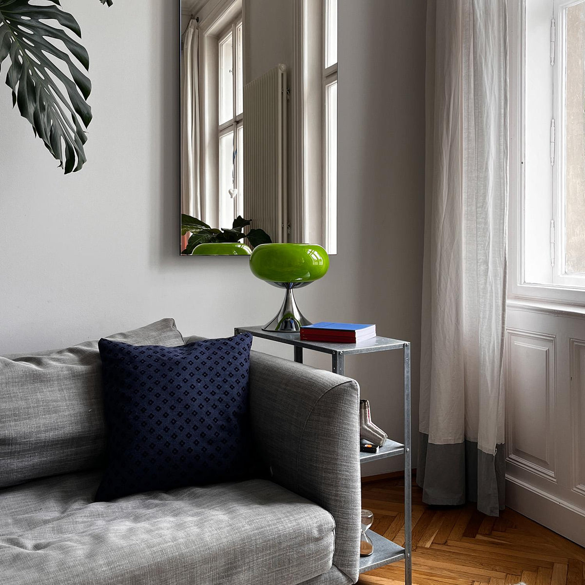 Retro bordlampe i grøn placeret på et sidebord i en stilfuld stue med skandinavisk indretning. Ideel til moderne hjem.