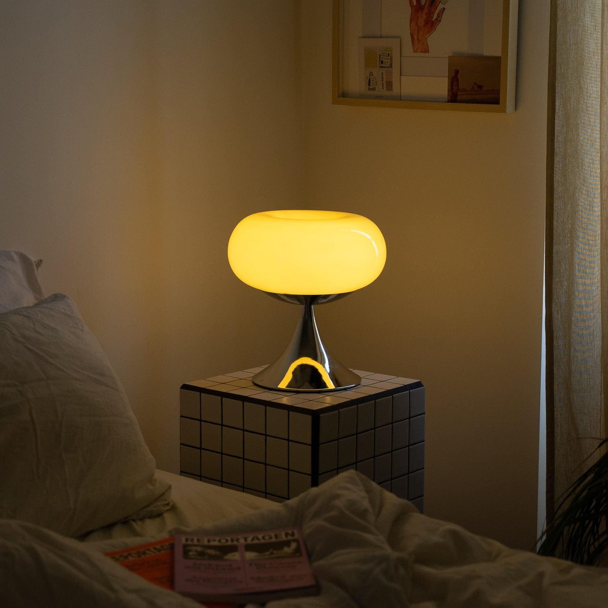 Vintage skrivebordslampe tændt på natbordet, skaber en hyggelig atmosfære i soveværelset. Perfekt som dekorativ belysning i retro stil.