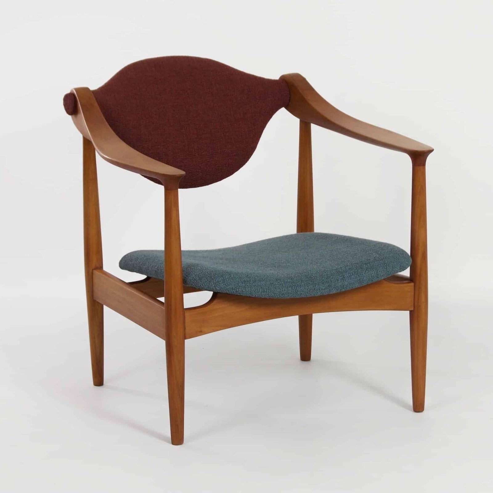 Danish wooden armchair from the 1960s with curved armrests and upholstery in burgundy and turquoise. Restored retro design in mid-century style.