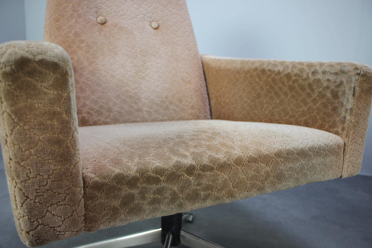 Frontdetalje af dansk design lænestol fra 1970&#39;erne, camel-farvet stof med knapdetaljer og komfortabel polstring.