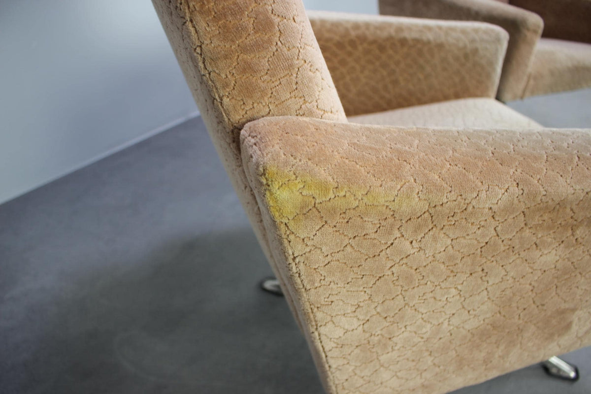Slidmærker på armlæn af vintage lænestol fra 1970&#39;erne, camel-farvet stof og metalstel, ideel til retrointeriør.