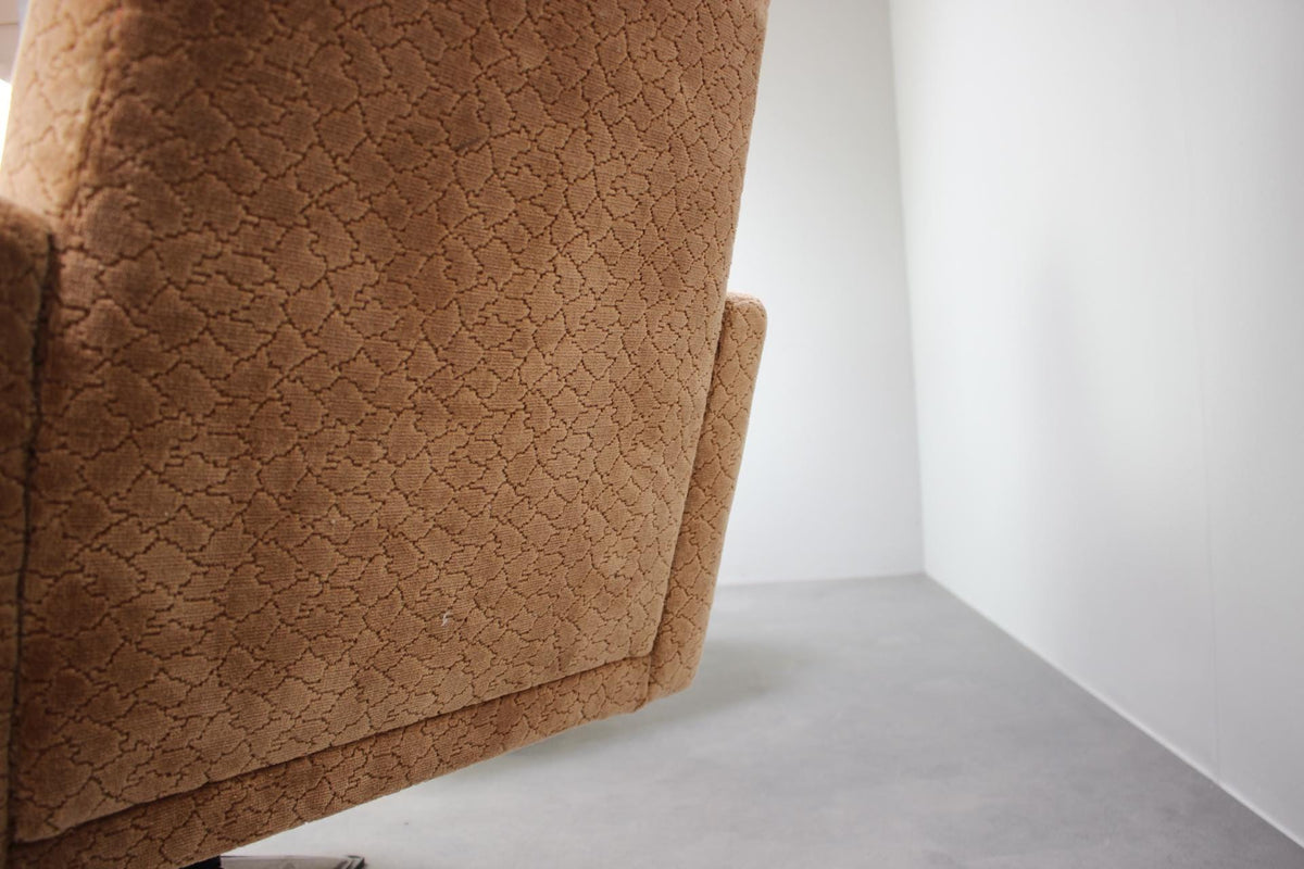 Nærbillede af ryglæn og armlæn på dansk design lænestol fra 1970&#39;erne, camel-farvet stof med retro tekstur.