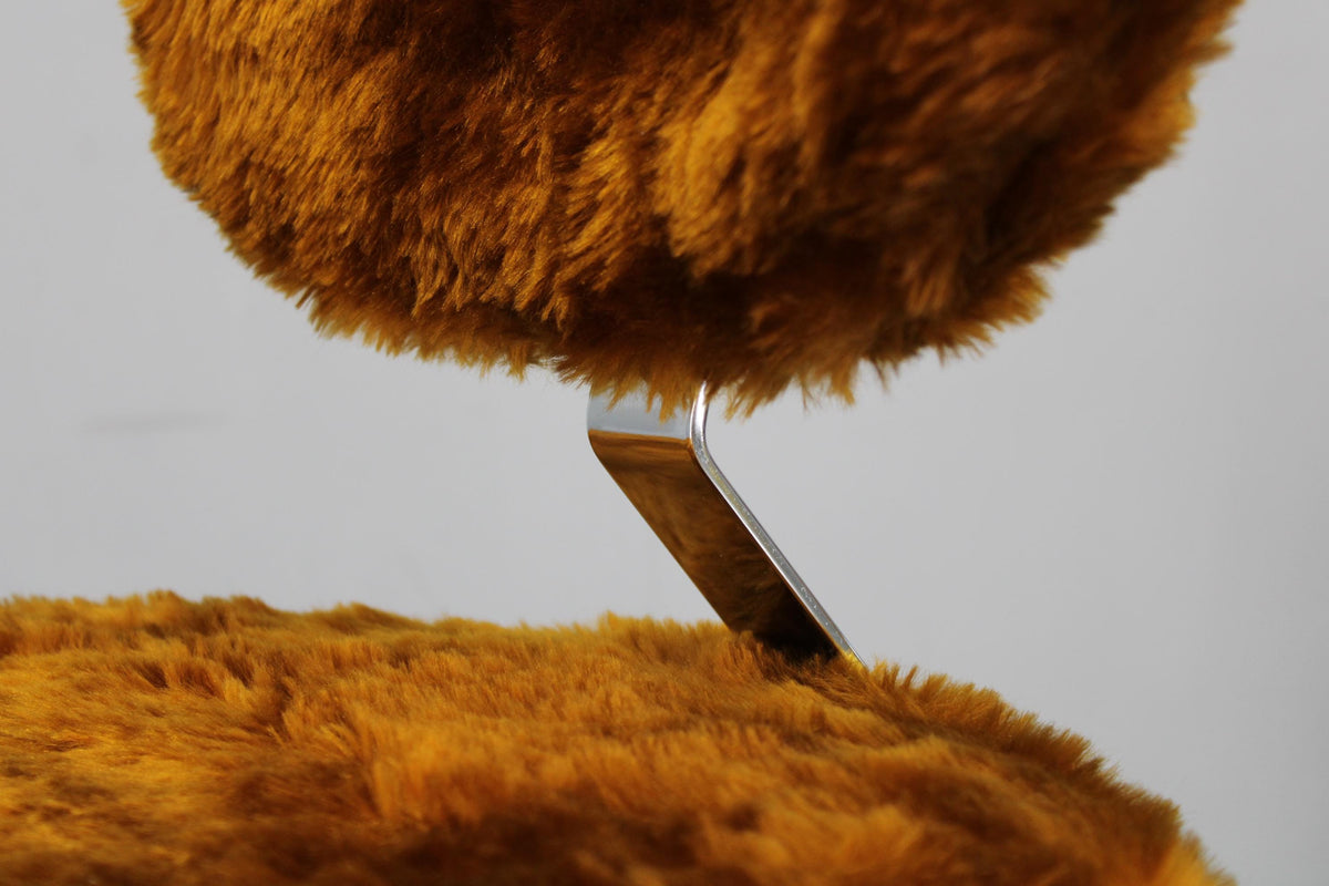 Polstret lænestol i langhåret stof, perfekt til en varm og personlig indretning.