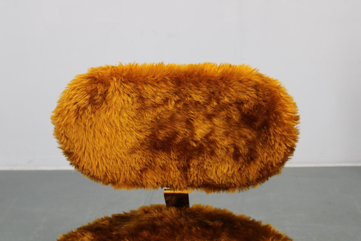 Vintage-inspireret lænestol betrukket med langhåret tekstil for maksimal komfort og karakter.