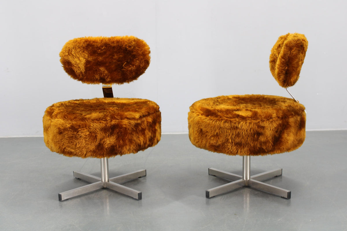 To elegante lænestole betrukket med langhåret, blødt stof, der giver et varmt og sanseligt udtryk. 