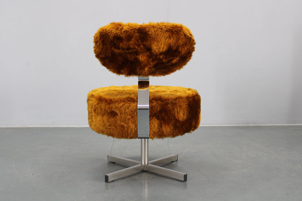 Statement-lænestol med taktilt langhåret betræk og organisk form.