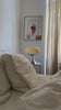 Retro desk lamp in ecru color placed on the bedside table in a minimalist bedroom. Creates a cozy and stylish atmosphere.