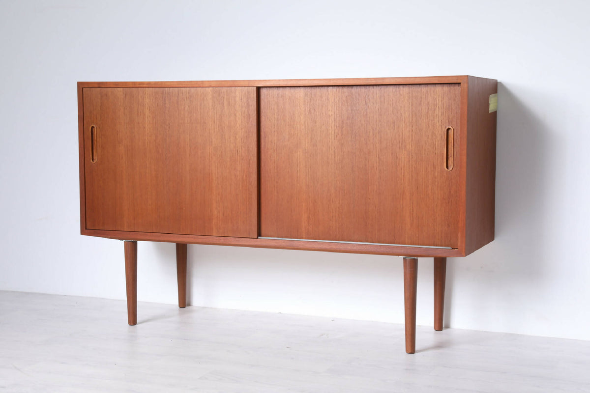 Poul Hundevad skænk i teak med slanke ben og skydelåger. Vintage møbel med praktisk opbevaring og klassisk dansk design.