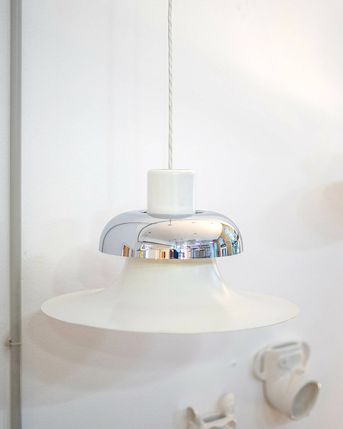 Detaljeret visning af Mandalay pendellampe fra Louis Poulsen med retroæstetik og hvid finish. Shop Mandalay pendellampe fra Louis Poulsen I SPLISH.