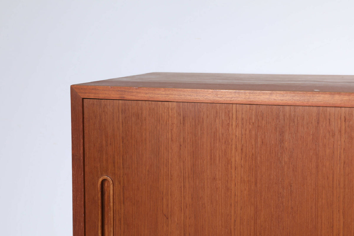 Detalje af Poul Hundevad skænk i teak, der viser det fine træhåndværk. Elegant hjørnekonstruktion og integrerede greb på skydelågerne.