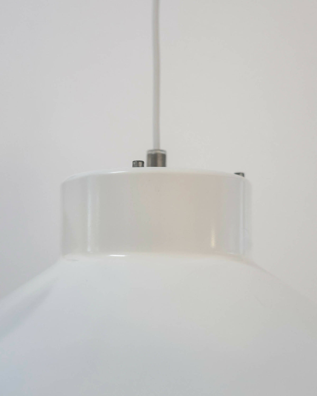 Topdetalje af Visir pendellampe i hvid fra Louis Poulsen. Minimalistisk design med synlige skruer og ophæng.